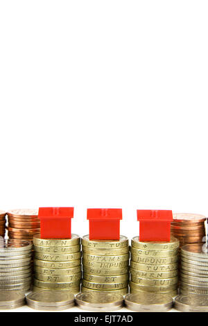 Roten Kunststoff-Häuser auf britischen Münzen, Wohnungsmarkt zu zeigen Stockfoto