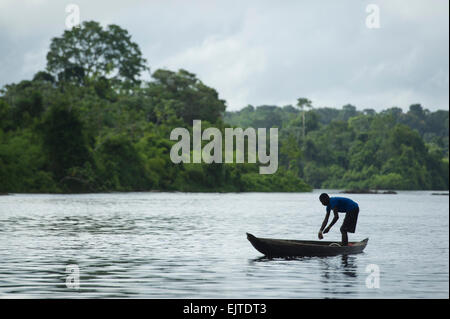 Kastanienbrauner junge Angeln von einem Boot auf dem oberen Suriname River, neue Aurora, Suriname Stockfoto