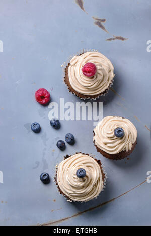 Schokoladentörtchen mit butter Kaffee Sahne und frische Beeren über grau Metall Surfave. Ansicht von oben. Stockfoto