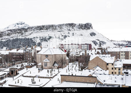 Edinburgh im Winter Serie. Suche von Regent Rd in Richtung Arthur Seat, mit Canongate Kirk und Friedhof im Vordergrund. Stockfoto