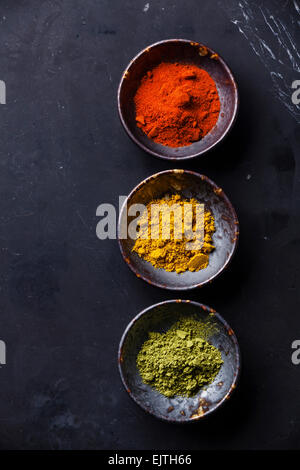 Gewürze-Curry, Paprika, Matcha-Tee auf dunklem Marmor Stockfoto