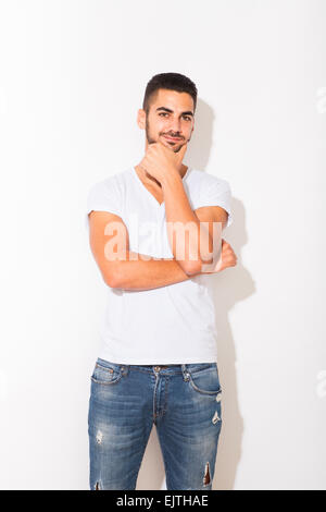 hübscher hispanic Mann im weißen t-Shirt mit Schatten auf weißem Hintergrund Stockfoto