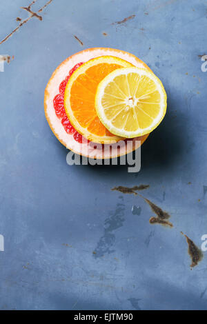 In Scheiben geschnitten Zitrusfrüchten Zitronen-, Orangen- und Grapefruitsaft über blaue Metalloberfläche. Ansicht von oben. Stockfoto