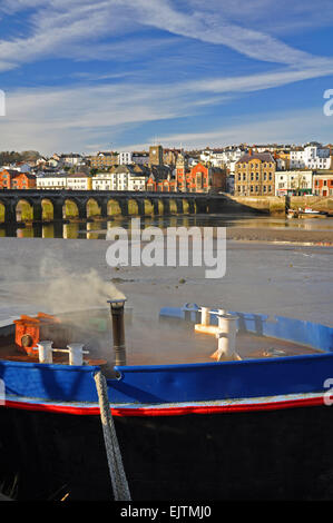 Ein altes Boot an Wooda Wharfe mit der Brücke hinaus auf den Fluss Torridge, Bideford, North Devon, England Stockfoto