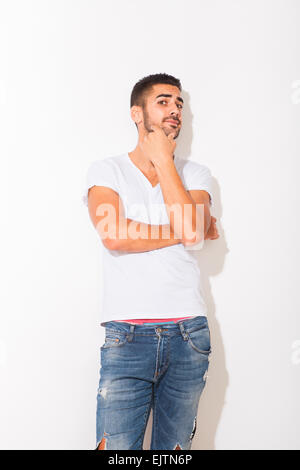 hübscher hispanic Mann im weißen t-Shirt mit Schatten auf weißem Hintergrund Stockfoto