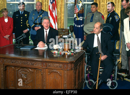 US-Präsident Bill Clinton beschreibt Waffenkontrolle während seiner wöchentlichen Adresse im Oval Office des weißen Hauses wie ehemaligen Reagan Pressesekretär James Brady am 5. März 1997 in Washington, DC aussieht. Stockfoto