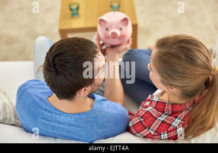 Nahaufnahme eines Paares mit Sparschwein auf sofa Stockfoto