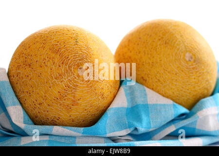 Zwei Galia Melone auf weiß-blau kariertes Geschirrtuch, Weichzeichner, Top isoliert Stockfoto