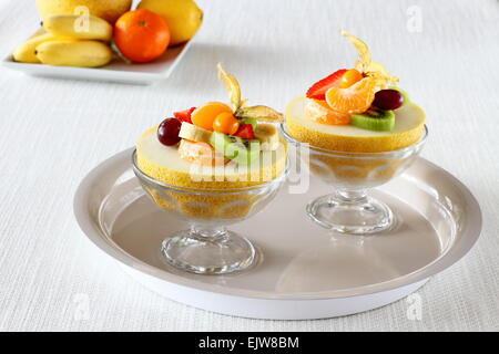 Zwei halbe Galia Melone gefüllt mit Sommerfrüchten, gesunde Ernährung Stockfoto