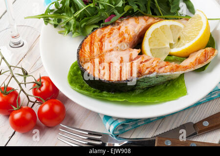 Gegrillter Lachs und Whtie Wein auf Holztisch Stockfoto