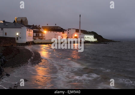 Bowmore Distillery in der Abenddämmerung mit Küstenlinie und Läppen Meerwasser Stockfoto