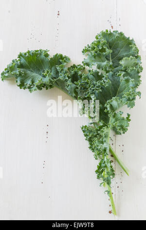 Grünkohl lässt auf eine Creme farbigen hölzernen Hintergrund. Stockfoto