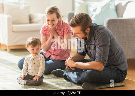 Glückliche Eltern sitzen mit kleinen Sohn (2-3 Jahre) Erdgeschoss Stockfoto