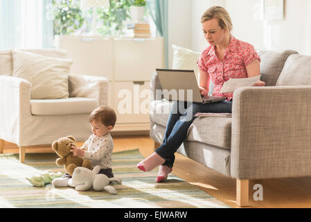 Arbeiten Mutter und Sohn (2-3 Jahre) im Wohnzimmer Stockfoto