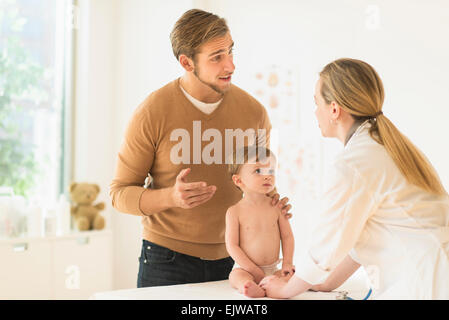 Kleiner Junge mit seinem Vater und Frau Doktor in Arztpraxis (2-3) Stockfoto