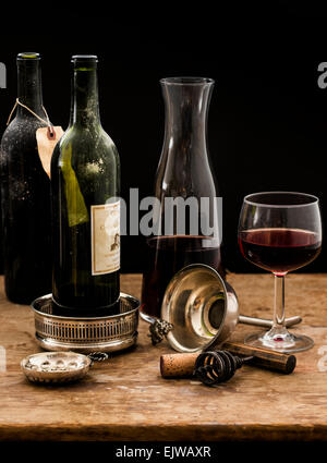 Stillleben mit Karaffe, Rotweinglas und Flaschen auf Holztisch, Studio gedreht Stockfoto