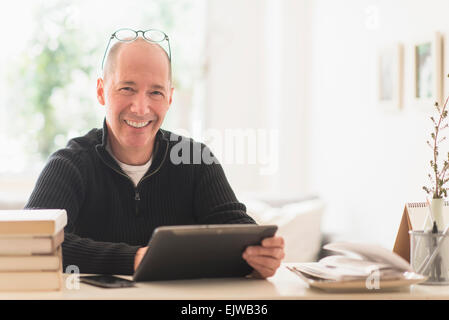 Porträt von lächelnden reifer Mann arbeiten im home-office Stockfoto