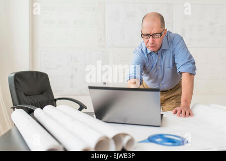 Ältere Architekten mit Laptop im Büro Stockfoto