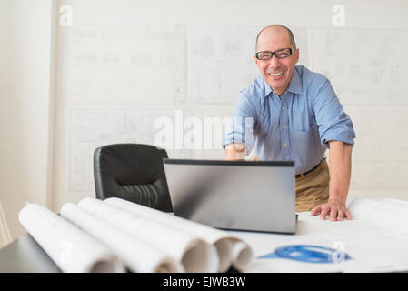 Porträt des lächelnden Reife Architekten mit Laptop im Büro Stockfoto