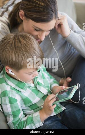 Mutter und Sohn (6-7) Musik hören Stockfoto