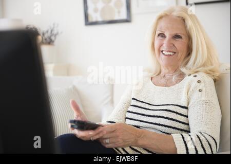 Ältere Frau Betrieb Fernbedienung Stockfoto