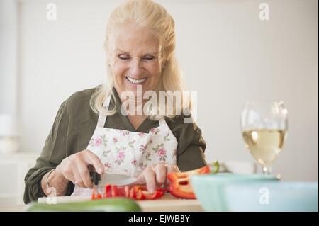 Ältere Frau schneiden Pfeffer Stockfoto