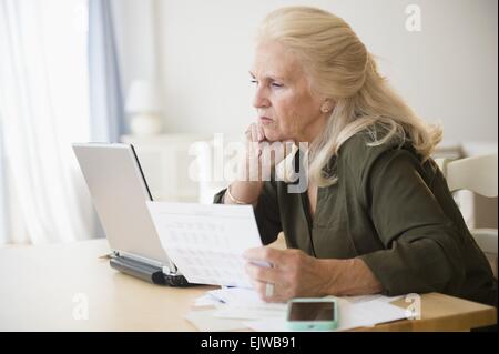 Ältere Frau Rechnungen online bezahlen Stockfoto