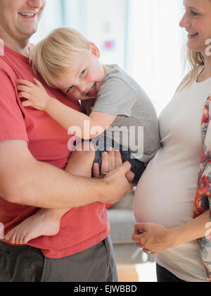 Fröhlicher Junge (2-3) verbringt Zeit mit seinen Eltern im Wohnzimmer Stockfoto