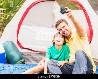 USA, Florida, Jupiter, Vater und Sohn (12-13) nehmen Selfie vor Zelt Stockfoto