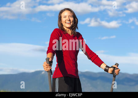 USA, Montana, Felchen, Portrait von lächelnden Frau mit trekking-Stöcke Stockfoto