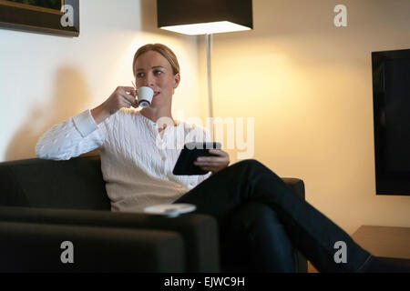 Frau mit digital-Tablette und trinken Kaffee zu Hause Stockfoto