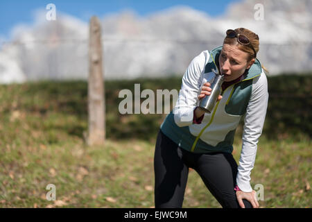 Österreich, Salzburger Land, Maria Alm, Frau trinkt aus Flasche Stockfoto