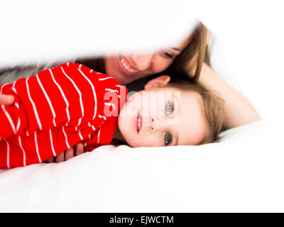 Mutter und Tochter (2-3) im Bett liegend Stockfoto