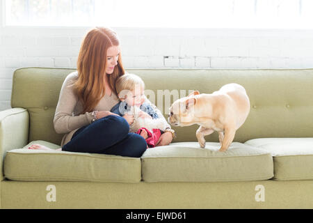 Mutter und Sohn (2-3) auf Sofa Blick auf Mops Stockfoto