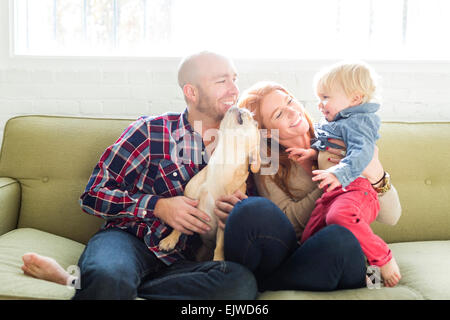 Familie mit Sohn (2-3) und Mops auf sofa Stockfoto