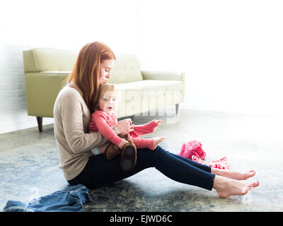 Mutter putzt Sohn im Wohnzimmer (2-3) Stockfoto