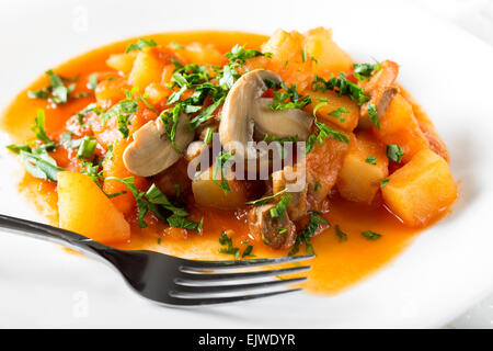 Kartoffeln mit Pilzen auf weißen Teller mit Gabel Stockfoto