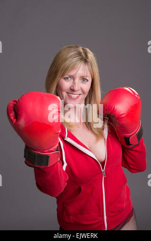 Frau kämpft Passform und rote Boxhandschuhe und Jacke Stockfoto