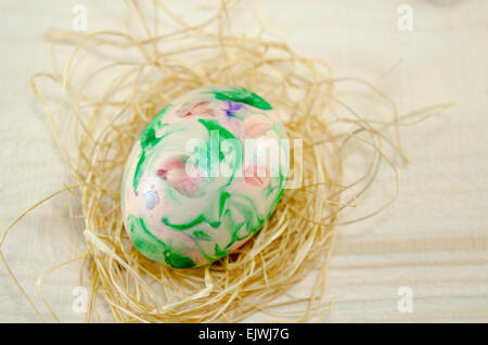 Handbemalte Ostereier auf einem Holztisch mit Stroh dekoriert Stockfoto