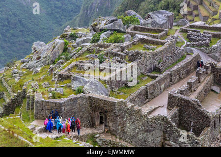 Peru, Machu Picchu.  Früh am Morgen leichter Regen fallen.  Touristen in bunten Ponchos Eingangsportal in die Stadt zu betreten. Stockfoto