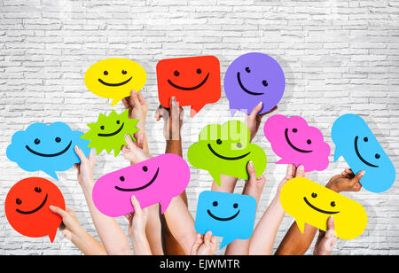 Hände halten Smiley-Gesichter-Symbole. Stockfoto