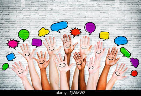Der Multi-ethnischen Menschen Handzeichen mit Sprechblase von Mauer. Stockfoto