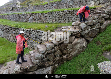 Peru, Machu Picchu.  Denkmalpflege.  Arbeitnehmer, die Messung in Verbindung mit Konservierungsarbeiten im Gange. Stockfoto