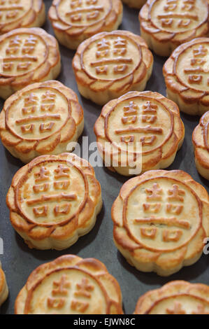 Nahaufnahme von gut gebackene frische Mooncakes auf ein Backblech. Der Text ist "Gil" und bedeutet Glück. Stockfoto