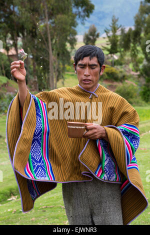 Peru, Urubamba-Tal, Quechua Dorf.  Priester, Durchführung einer Willkommenszeremonie für Gäste, Beregnung Chicha den Geistern. Stockfoto