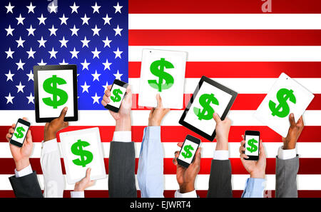 Multi-ethnischen Gruppe von Geschäftsleuten Haltevorrichtungen Technologie mit einem Dollar-Zeichen auf einem Bildschirm und die amerikanische Flagge als Hintergrund Stockfoto