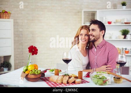Glückliches junges Paar Tisch sitzen und einem Abendessen in der Küche Stockfoto