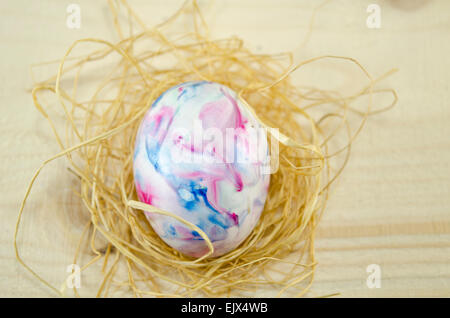 Handbemalte Ostereier auf einem Holztisch mit Stroh dekoriert Stockfoto