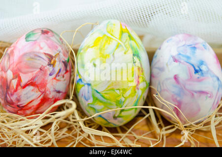 Handbemalte Ostereier auf einem Holztisch mit Stroh dekoriert Stockfoto