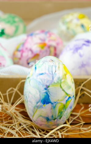 Handbemalte Ostereier auf einem Holztisch mit Stroh dekoriert Stockfoto